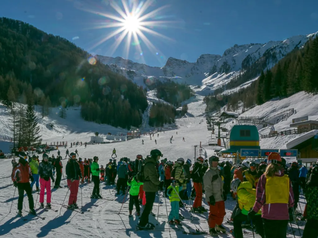 Blick gegen die Sonne über die Piste ins Tal.